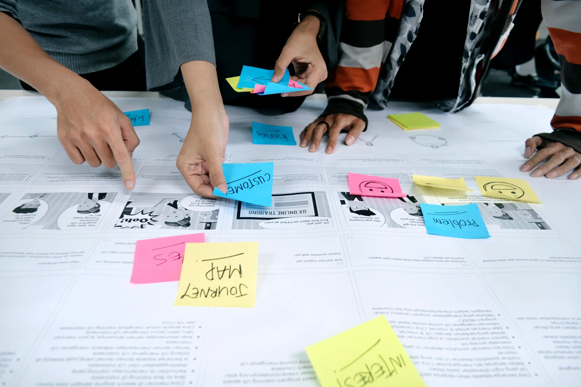 Journey-mapping session with sticky notes over a printed storyboard.